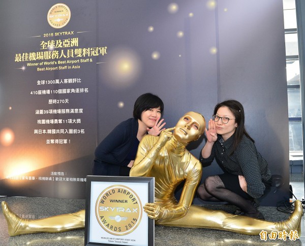 桃園機場金特別舉辦「小金人快閃活動」,吸引不少旅客與金人合照。(記者姚介修攝)