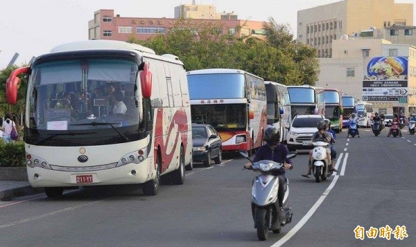 中國客遊覽車停在路邊,造成機車騎士騎上快車道。(記者葛祐豪攝)