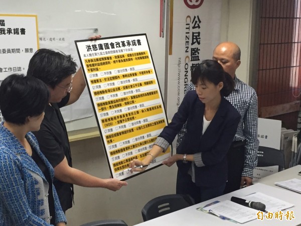 洪慈庸在鄭麗君、公督盟見證下簽署自我承諾書。(記者蘇芳禾攝)