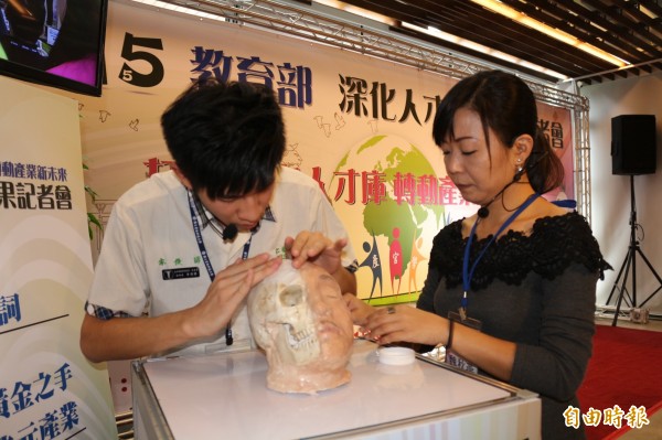 仁德醫專學生李俊諺（左）示範遺體顏面修復技術。（記者詹士弘攝）