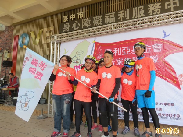 台中市愛心家園園長陳怡君(左1)授旗給單車隊。(記者張菁雅攝)