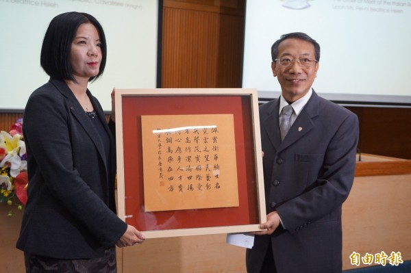 靜宜大學校長唐傳義頒發藏頭詩給傑出校友謝佩霓。(記者歐素美攝)
