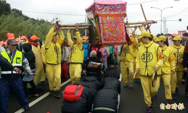 通霄鎮拱天宮白沙屯媽祖鑾駕,今天返回苑裡及通霄市區,沿途信眾爭相鑽轎腳。(記者張勳騰攝)
