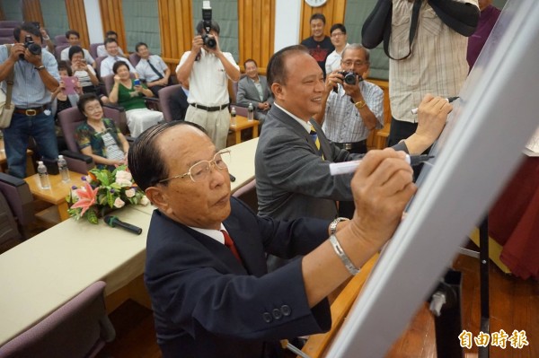 宜蘭縣長林聰賢（後）與薛長興集團董事長薛丕拱（前），共同在合約書上簽名。（記者林敬倫攝）