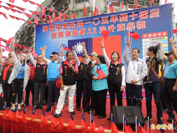 國旗屋米干店老闆張老旺(中)帶領參加升旗典禮的民眾高呼「中華民國萬歲」口號。(記者周敏鴻攝)