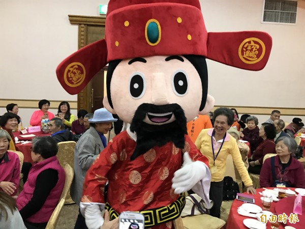 老盟今天舉辦「用愛暖冬溫馨團圓情」圍爐活動,財神爺一出來,立即獲得在場老寶貝歡心。(記者陳炳宏攝)