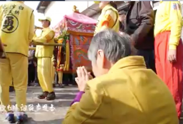 婦人跪地不斷向媽祖神轎磕頭。(翻攝黃朝業臉書)