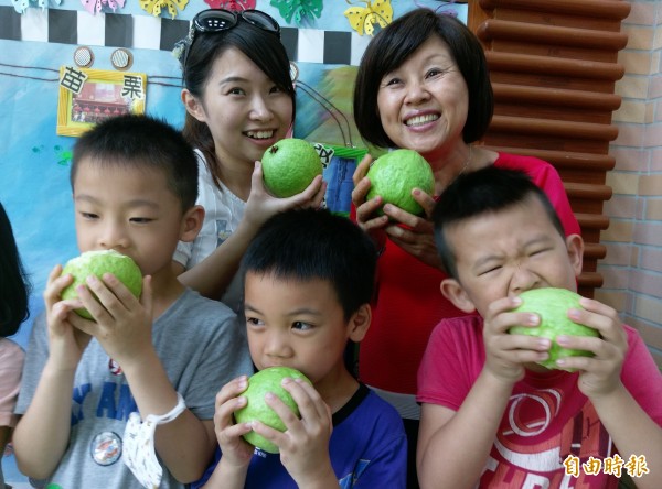 環球幼兒園小朋友大口咬下芭樂,將滿滿維他命C吃下肚。(記者詹士弘攝)