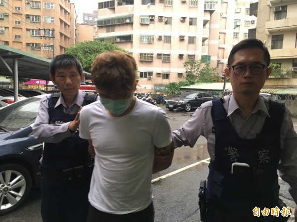 通緝犯游男(中)搭乘友人的轎車,結果因為有人違規停車被警方逮捕。(記者邱奕統攝)