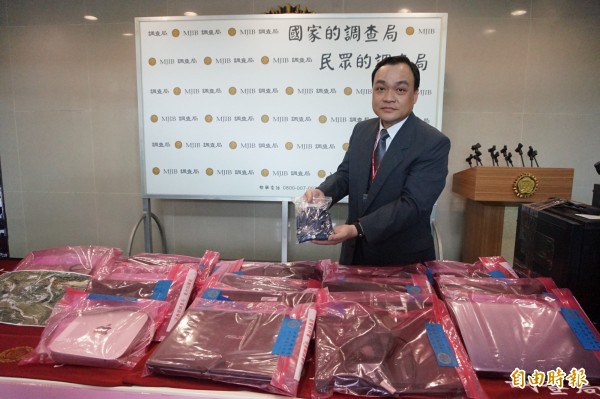 航調處副主任吳幸燦展示查扣的USB及筆電等不法物證。（記者歐素美攝）