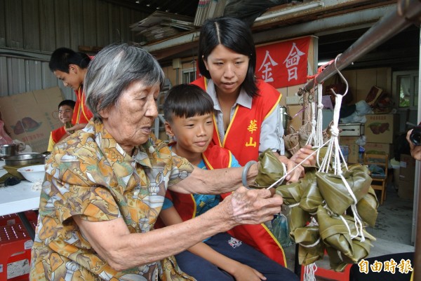 張婦和學童樂包粽。(記者陳彥廷攝)