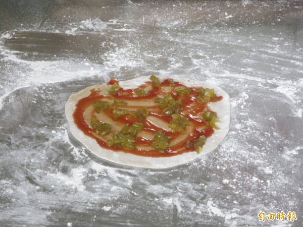 水里郡坑國小舉辦梅子披薩體驗活動，師生們跟著廚師將梅果放進餅皮，品嘗從未嘗試過的酸甜披薩滋味。（記者劉濱銓攝）