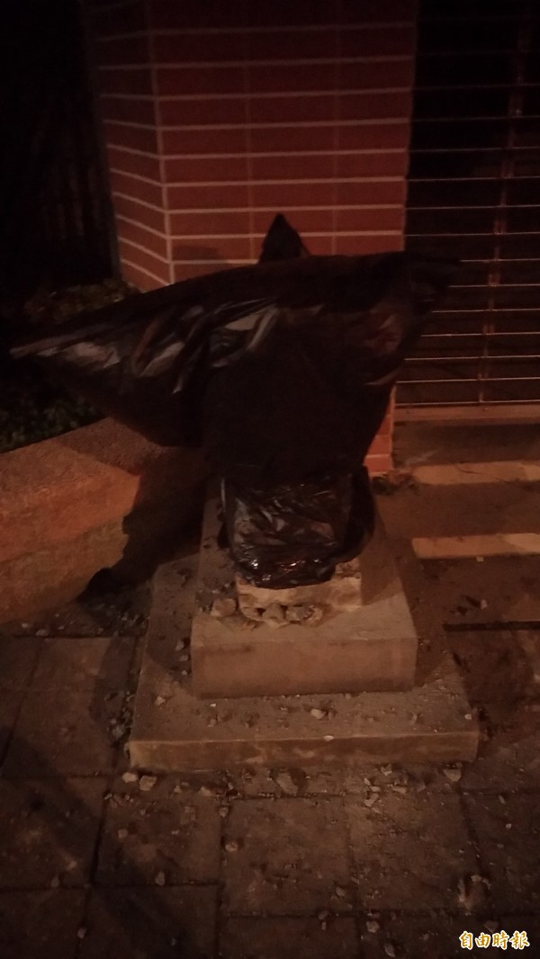 兩隻石狛犬已被警方用黑色塑膠袋罩住。（記者鄭景議攝）