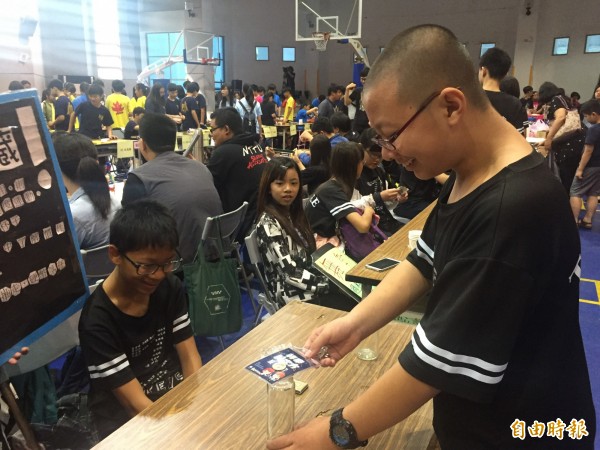 慣性讓錢幣掉落瓶中。（記者張存薇攝）