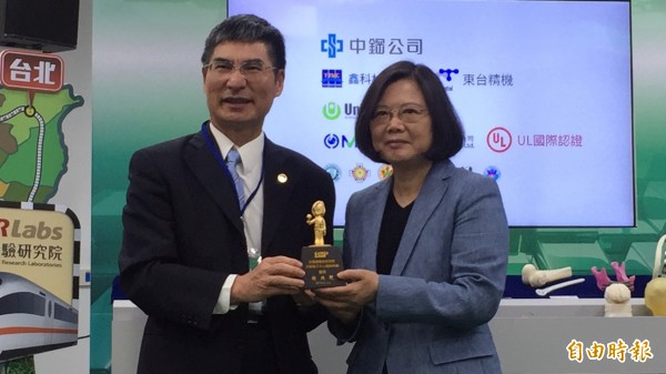 小英總統從科技部長陳良基手中接過3D列印的鈦合金小英公仔。(記者黃美珠攝)