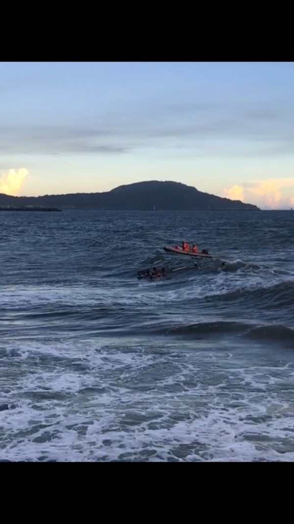 25歲女子傍晚與母親到高雄蚵仔寮漁港散步，卻突然落海，救難人員冒險在海浪裡將她救起。（記者黃佳琳翻攝）