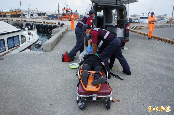 澎湖縣政府消防局人員，在岸邊接力搶救溺水女潛客。（記者劉禹慶攝）