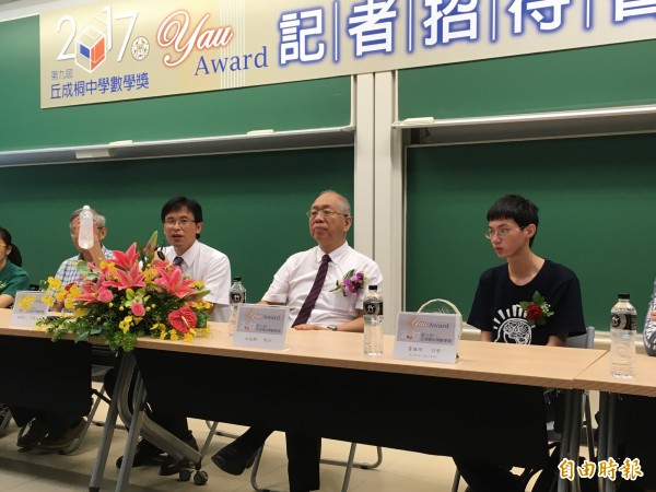 台大數學系主任陳榮凱（左二）用保特水瓶說明黃維坪（右一）的金牌作品，一個水瓶從底部看和從側面看不同，探討更多有關幾何的知識。（記者林曉雲攝）