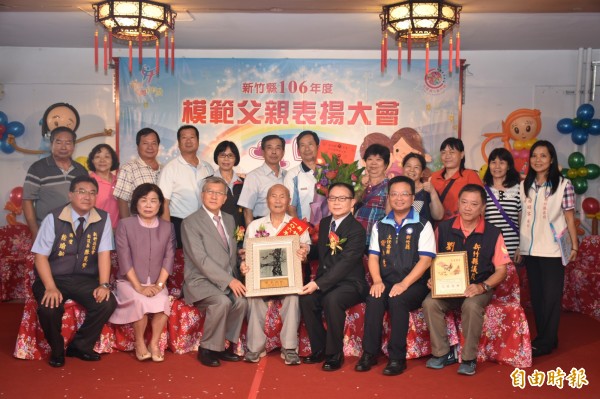 新竹縣父親節模範父親表揚活動,由縣長邱鏡淳(前排左3)和議長張鎮榮(前排右3)逐一頒獎給96歲模範父親林礽樹等13鄉鎮市代表,並與受獎家屬合影留念。(記者廖雪茹攝)
