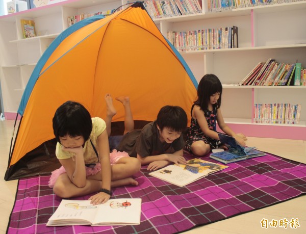 新北市圖舉辦夜宿圖書館活動,將帳篷、野餐墊搬進圖書館,讓小朋友學搭帳棚,與書香共眠。(記者葉冠妤攝)