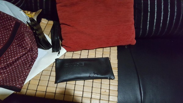 約20分鐘後員警從沙發椅旁一個朔膠袋內衣物中找到黑色隨身包。（記者許國楨翻攝）（記者許國楨攝）