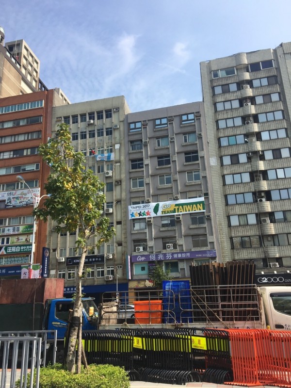 台北田徑場對面的公寓大廈，也因住戶不同立場，掛出綠色台灣意象標語及中華民國國旗。（民眾提供）