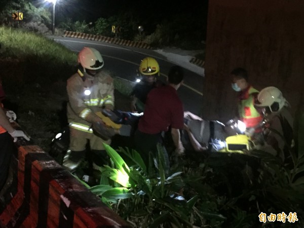 消防隊員們將王姓騎士搬到平面道路上。（記者吳昇儒攝）