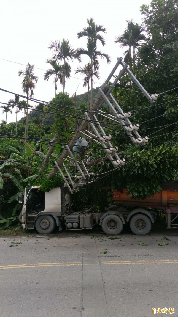 一輛砂石車閃車不慎撞倒電線桿，造成電桿嚴重傾斜，阻礙往來交通。（記者劉濱銓攝）