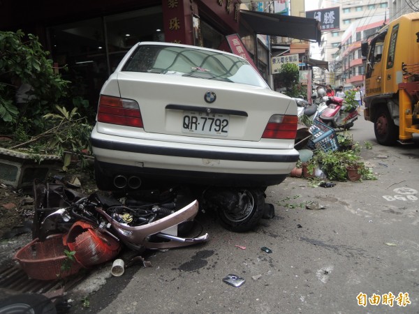 機車被壓在BMW下方。（記者張軒哲攝）