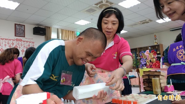 26歲的王彥之（左）有條不紊地教大家製做手工皂，還頻頻謝謝大家買他的香皂。（記者廖淑玲攝）