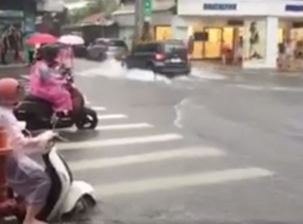 午後大雨造成嘉義市中山路部分地區積淹水，汽車行經水花濺起有半個輪胎高。（翻攝綠豆嘉義人臉書）