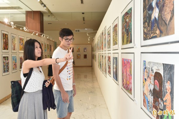 今天是七夕情人節，這對情侶也來觀賞「世界兒童繪畫巡迴展」。（記者張忠義攝）