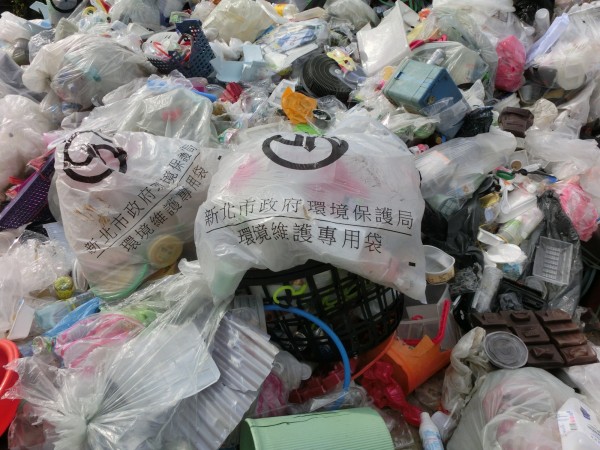 大溪查獲現場偷倒許多印有「新北市環保局」字樣的袋裝資源回收物，意外查出行竊漂流木的「案外案」。（記者李容萍翻攝）