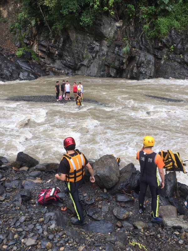 5位民眾在河床上等待救援，約在下午2點全數獲救。（記者陳薏云翻攝）