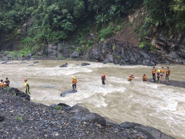 5位民眾在河床上等待救援，警消直接渡河搶救。（記者陳薏云翻攝）