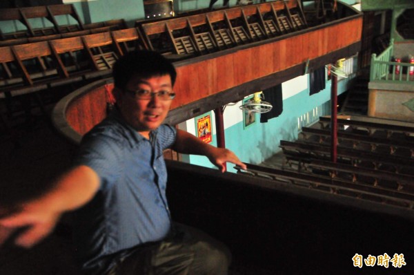 瑞舞丹大戲院第4代陳威僑，蹲坐在戲院2樓欄杆前說，這裡曾是童年的他最棒的VIP席。（記者花孟璟攝）