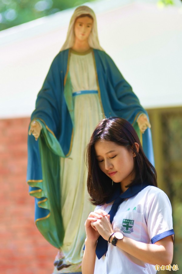 花蓮天主教海星中學由聖吳甦樂女修會創辦,修女雕像慈愛地俯視祈禱的少女。(記者花孟璟攝)