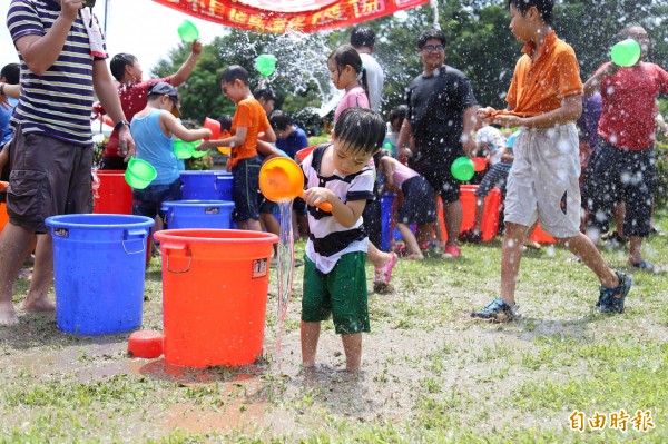 屏東地區今天上午氣溫悶熱，氣溫29至33度，體感溫度則達30至37度，不少民眾參加潑水節活動消暑。（記者邱芷柔攝）