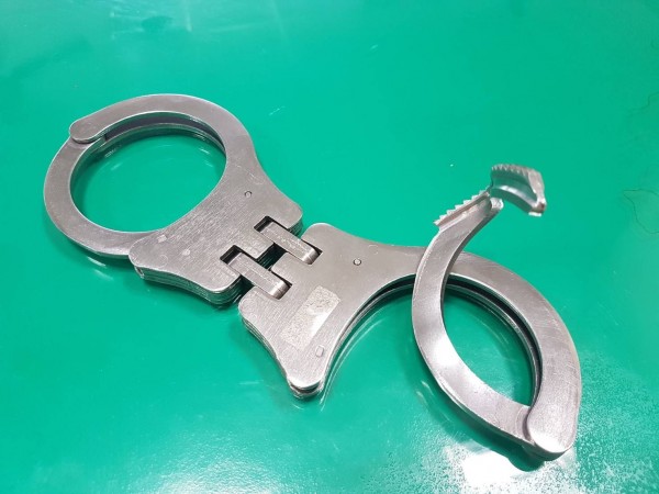 手銬也被蔣男扭彎。(記者張勳騰翻攝)