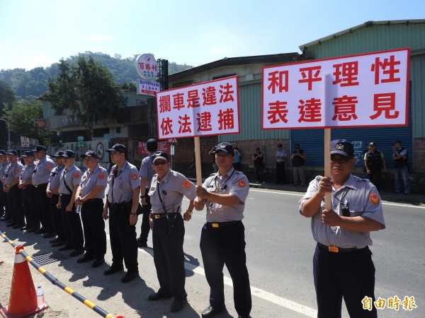 針對民眾計劃封路抗議，警方不敢大意，現場派駐大批警力，更高舉兩大看板，表達警方尊重民眾集會權利，但對違法行為也絕不寬貸。（記者佟振國攝）