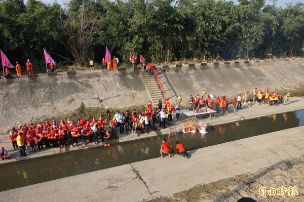 大士爺廟董監事們今天下午在民雄鄉文化路文隆橋下溪畔放水燈，廟方董監事引燃5座紙房子及放流108朵蓮花座，期接引水域冤死的孤魂乘坐水燈，參與普度大典。（記者曾迺強攝）