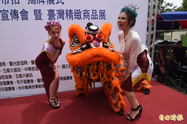 外國佳麗酷愛舞獅,爭相與它合影。(記者李忠憲攝)