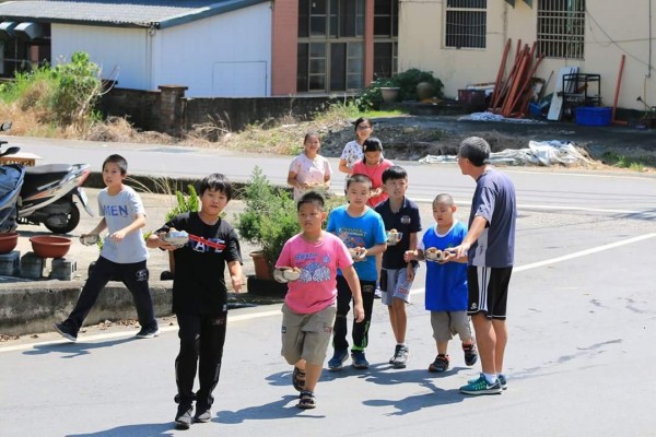 田豐國小老師林鶴林班上的小朋友走出校門，到活動中心送烤地瓜給老人家。