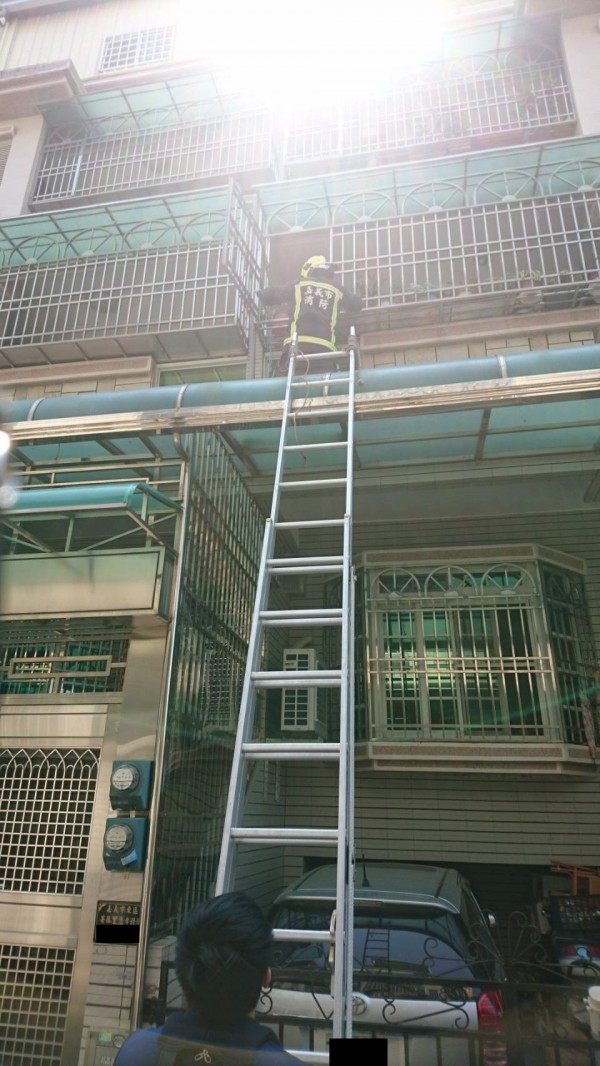 後湖消防分隊消防員架梯從二樓開窗入屋，助2歲吳姓男童脫困。（記者王善嬿翻攝）
