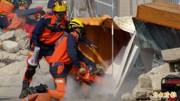 新北市政府今天舉辦「災害醫療救援隊」DMAT成軍演練，模擬救援瓦礫堆中的受困患者。（記者吳仁捷攝）