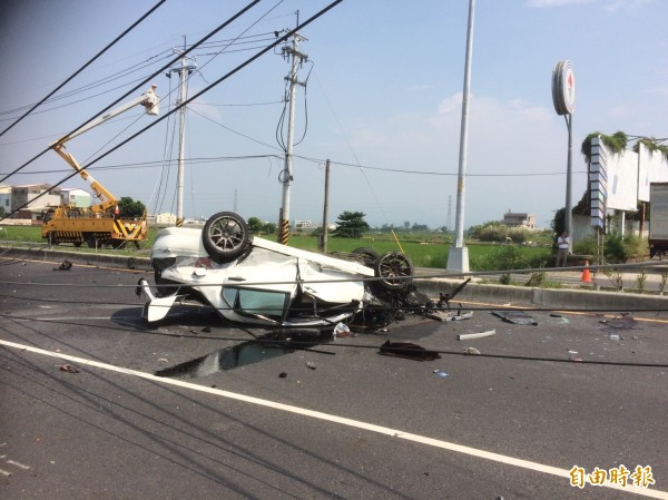 事故車躺在路中，車頭幾乎全毀。（記者林國賢攝）