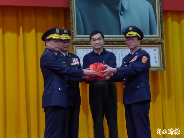 北市警局举行卸新任局长交接典礼,新任局长陈嘉昌(右1)在副市长邓家基(右2)与警政署长陈家钦(左2)的监交下,自代替邱丰光出席的副局长林顺家(左1)手中接下印信。(编辑王冠仁摄)