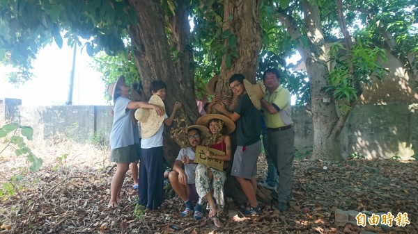 台南社大環境行動小組研究員吳仁邦（右一）和堀仔頭生態藝術村成員環抱白蓮霧老樹表達護樹。（記者楊金城攝）