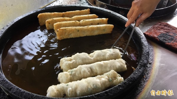 油鍋裡的鹹油條逐漸變成金黃色澤，得定時翻面，均勻受熱，大約5至7分鐘完成。（記者佟振國攝）