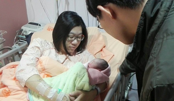 今天國慶寶寶來報到,母親滿足之情流露無遺,在一旁守候的丈夫與醫護人員也十分開心。(記者湯世名翻攝)